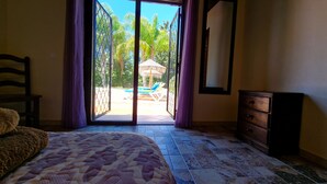 A bedroom with a bed, a dresser, and a view of an outdoor pool area through a sliding glass door. - Quiet Villa with heated swimming pool, barbecue and views. (Alhaurín el Grande)