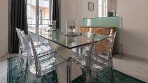 Eine moderne Küche mit einem Glastisch, klaren Stühlen und einem grünen Schrank.