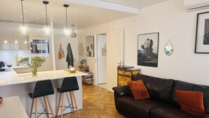 A modern living space with a kitchen, dining area, and a leather sofa.
