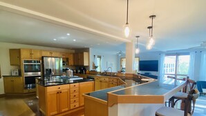 A spacious kitchen with wooden cabinets, a large island, and modern appliances.
