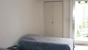 A room with two single beds, a white wardrobe, and a sliding glass door leading to an outdoor area. - Three bedroom, two bathroom apartment in Cannes with large terrace - 880 (Cannes)