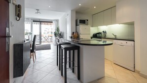 A modern kitchen with a central island, bar stools, a microwave, a refrigerator, and a dishwasher. - Modern 3BR/3BA cannes apt walk to Palais - 2000 (Cannes)