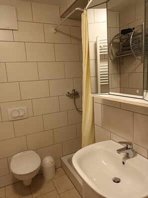 Business studio | Badkamer | Een douche, een haardroger, handdoeken, toiletpapier