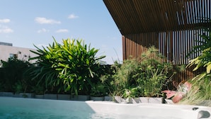 A swimming pool with hot tubs, surrounded by lush greenery and a wooden pergola. - Luxury Penthouse&Private Roof and Pool (Tel Aviv)