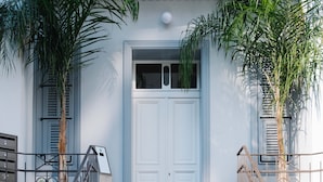 A white building with a white door, a set of concrete stairs, and metal railings. - Luxury Penthouse&Private Roof and Pool (Tel Aviv)