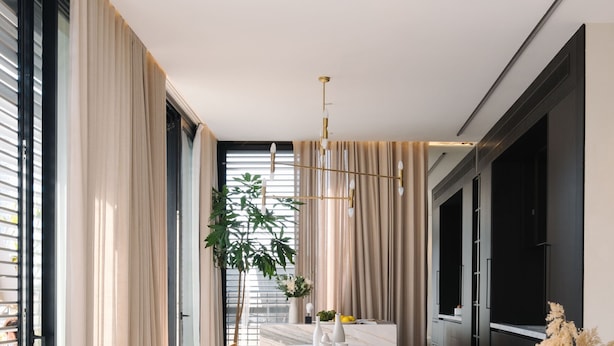 A modern living room with a white sofa, a dining table with chairs, and a large window with curtains. - Luxury Penthouse&Private Roof and Pool (Tel Aviv)