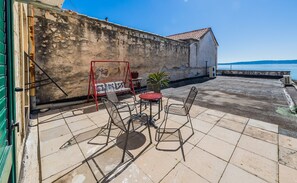 A patio with outdoor furniture, a swing, and a view of the sea. - A 1 - Spacious apt on the Seafront With Terrace (Kastela)