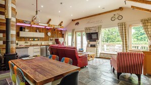 A cozy interior with a wooden dining table, red sofa, and a television. - 1 bedroom accommodation in Haswell, Nr Durham (Haswell, Nr Durham)