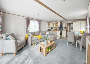 A modern living room with a sofa, coffee table, and dining area.