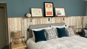 A neatly arranged bedroom with a bed, bedside tables, and framed pictures on the wall. - Downs Hotel (Brighton)