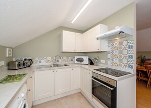 A compact kitchen with a built-in oven, a microwave, and a toaster.