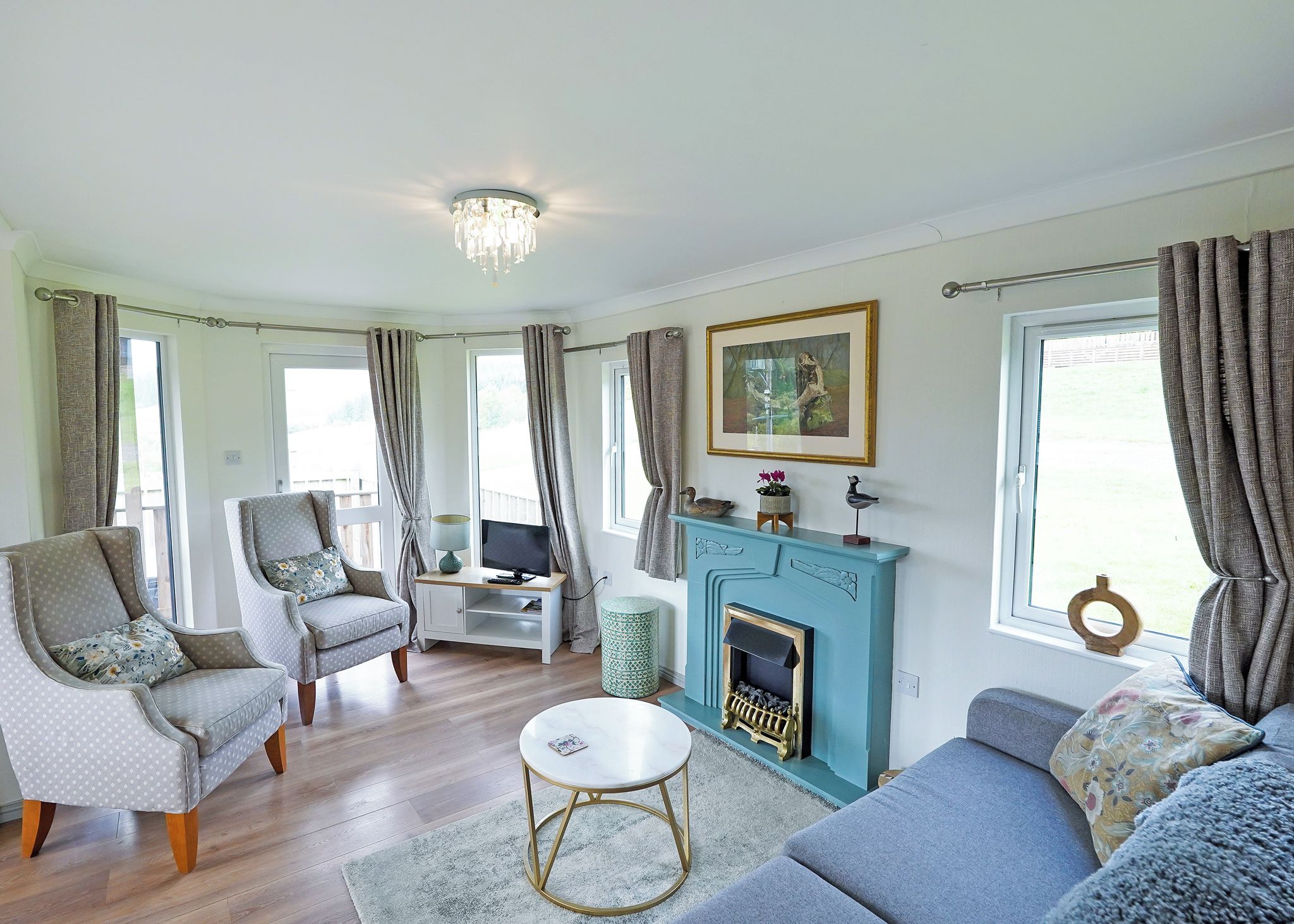 A living room with a fireplace, two sofas, a television, and a dining area.