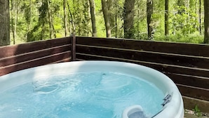 A hot tub with a wooden deck and a forest backdrop. - Woodland Rowan Lodge (Ellesmere)