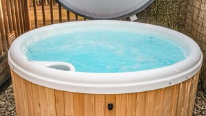 A wooden hot tub with a white interior, surrounded by a wooden deck and a metal fence. - One double with en suite shower and one twin. (Laxfield, Nr Woodbridge)
