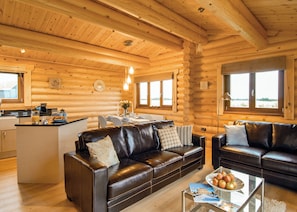 A log cabin interior with a living area, kitchen, and dining space. - One double with en suite shower and one twin. (Laxfield, Nr Woodbridge)