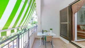 A balcony with a white table, chairs, and a potted plant. - Flamingo Coast by Fidalsa (La Zenia)
