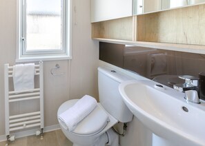 A modern bathroom with a toilet, sink, and towel rack.