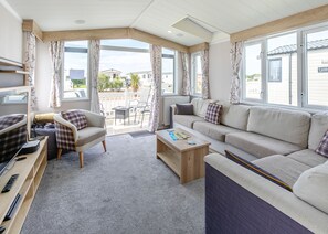 A cozy living room with a sofa, chairs, a coffee table, and a TV.