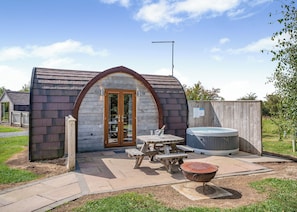 A small, single-story structure with a sloped roof, a wooden door, and a hot tub. - 1 bedroom accommodation in Great Busby (Great Busby)