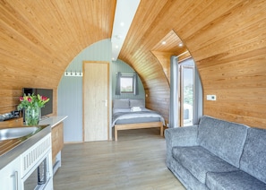 A cozy, compact room with a bed, a sofa, a small kitchen area, and a window. - 1 bedroom accommodation in Great Busby (Great Busby)