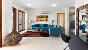 Una sala moderna con un sofá azul, una mesa de centro y un jarrón decorativo.