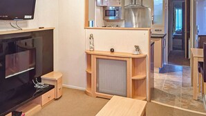 A modern kitchen with a microwave, oven, and a large stainless steel range hood. - Holiday home with one double with en suite, and one twin. (Tollerton, York)
