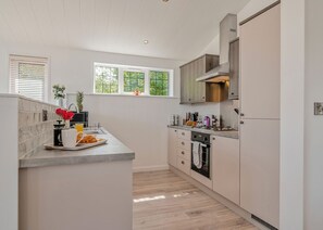 A modern kitchen with a central island, built-in appliances, and a window providing natural light.