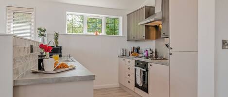 A modern kitchen with a central island, built-in appliances, and a window providing natural light.