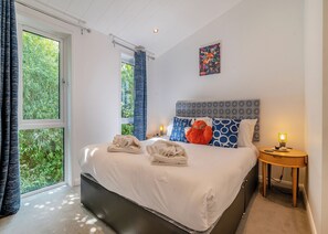 A bedroom with a large bed, a bedside table with a lamp, a window with curtains, and a painting on the wall. - 2 bedroom accommodation in Cannington (Cannington)
