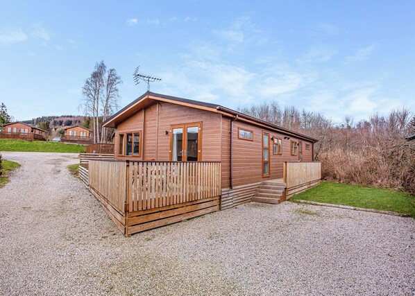 A wooden cabin with a gravel driveway, wooden deck, and a metal antenna. - 2 bedroom accommodation in Castlewood (Castlewood)