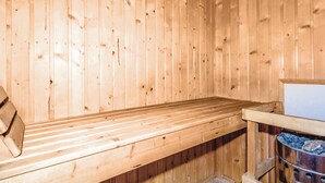 Eine Holzsauna mit einer Bank und einem Steinofen.
