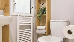A bathroom with a white toilet, a white radiator, a sink, and a window with a view of the sky. - Signature 3 Bed Caravan Pet (Morpeth)