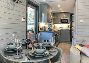 Una cocina compacta con zona de comedor, un sofá y vistas al exterior.