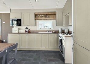 A modern kitchen with a central island, built-in appliances, and ample counter space. - Valley View 2 Bed Hot Tub Holiday Caravan Cawsand (St Ann&rsquo;s Chapel, Callington)