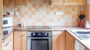 A kitchen with a microwave, oven, and sink. - Modern two bedroom lodge, one double and one twin with en suite shower. (Langworth)