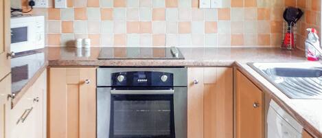 A kitchen with a microwave, oven, and sink.