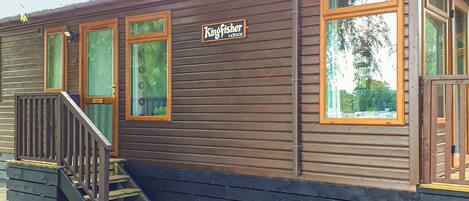 A Kingfisher Lodge building with a wooden exterior, a staircase, and a sign.
