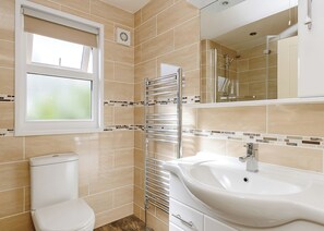 A bathroom with a toilet, sink, and shower.