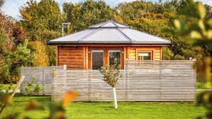 A wooden cabin with a sloped roof, a front door, and a small porch. - 1 bedroom accommodation in Fitling, Nr Hornsea (Fitling, Nr Hornsea)