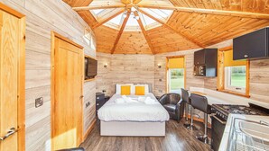 A wooden cabin interior with a bed, seating area, kitchen, and a large skylight. - 1 bedroom accommodation in Fitling, Nr Hornsea (Fitling, Nr Hornsea)