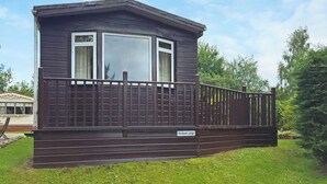 A mobile home with a balcony, a nameplate reading 'Kinclaven Lodge,' and a fenced deck area. - Kinclaven (No Hot Tub) (Cargill)