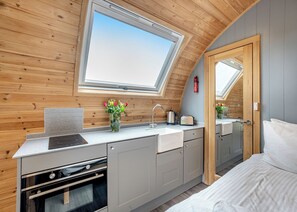 A compact kitchen with a skylight, a stove, and a sink.