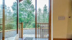A wooden door leading to a balcony with a gravel path and a metal grate.