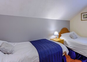 A hotel room with two beds, a nightstand with a lamp, and a framed picture on the wall. - Timber lodge set in an elevated woodland position with views of the lake. (Webbery, Bideford)