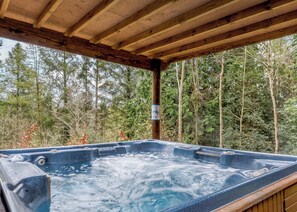 A hot tub under a wooden pergola with a forest view. - Timber lodge set in an elevated woodland position with views of the lake. (Webbery, Bideford)