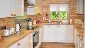 Une cuisine moderne avec des meubles en bois, un évier en acier inoxydable et un four encastré.