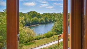 Une vue sur une rivière bordée d’une végétation luxuriante, avec une route qui longe ses rives.