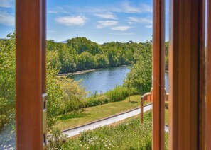 Vista de un río rodeado de abundante vegetación, con una carretera que lo acompaña.