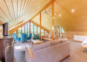 Une pièce confortable de style loft, dotée d’une grande fenêtre, d’une cheminée et d’un canapé.
