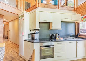 A compact kitchen with a microwave, oven, and coffee maker.